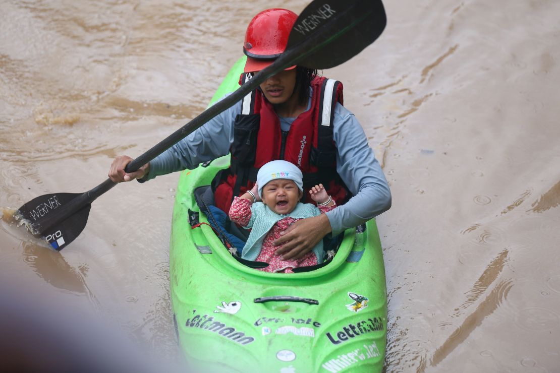 Nepal Army personnel evacuates an infant using a kayak from a flooded residential area in Kathmandu, Nepal, on September 28, 2024.