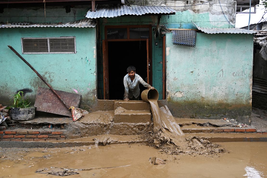 A man cleans mud from his house in a flood-affected area following heavy monsoon rains in Kathmandu on September 29, 2024.